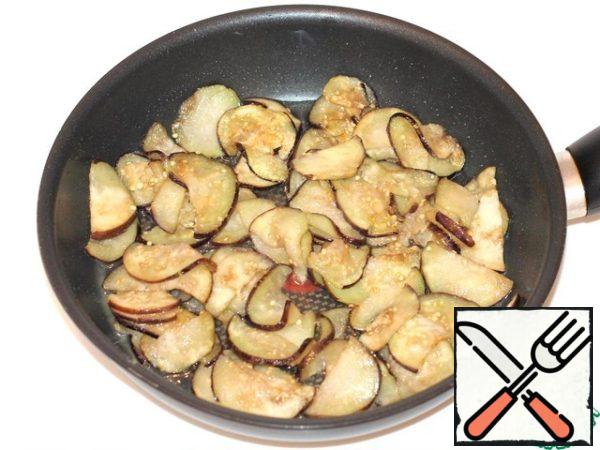 In a frying pan with heated vegetable oil, fry the eggplant pieces until an appetizing crust.
