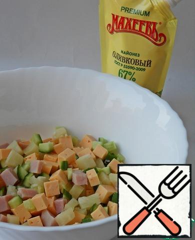 So, cut cheese, ham, canned pineapple and cucumber into medium cubes. Stir, season with mayonnaise.