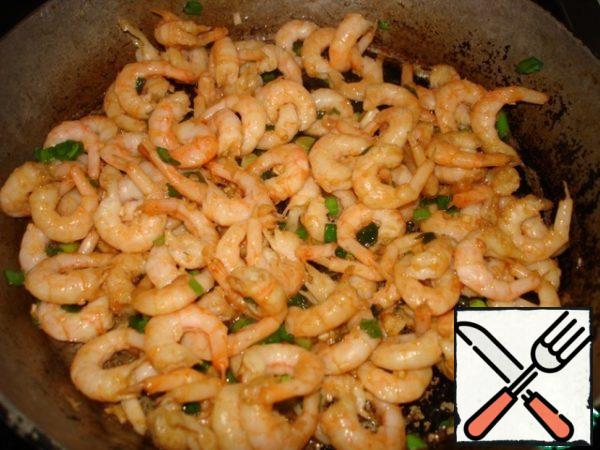 In a frying pan heat some oil, add chopped garlic, ginger. Then add the shrimp, chopped green onions. Fry. Add soy sauce at the end.