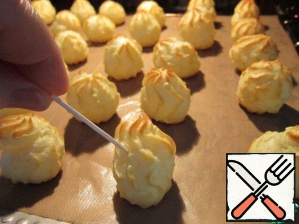 Bake in a preheated 200 degree oven for 20-25 minutes. 1-2 minutes before readiness, open the oven and gently pierce the profiteroles with a toothpick - let off steam. Then bake until cooked.
