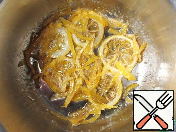 For candied fruits, remove the zest with a knife from one lemon in thin strips, then cut the strips of zest along into even thinner parts. Half a lemon, preferably another, cut into circles 0.4-0.5 cm thick. Remove the bones. Should get 5-7 pieces. In a small saucepan bring to a boil, stirring, a mixture of sugar and water, sugar should dissolve completely. Immerse in syrup both types of candied fruits, boil on low heat after boiling for about 15 minutes. Stirring is not necessary, only once shortly before the end of cooking, turn slices on the other side.