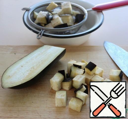 Cut the eggplant into cubes with a side of 2 cm, put in a colander or a sieve, sprinkle with salt generously, leave for 20 minutes.
Rinse with cold water and dry on a towel.
Here is a sprinkling eggplant with salt need is not for the bitterness to go away, and the eggplant has absorbed less oil.