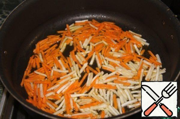 In a deep saucepan, heat a couple of tablespoons of vegetable oil and fry carrots with root celery until half-cooked.