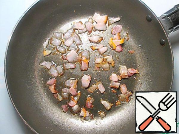 Finely chop the bacon and fry it in a dry pan for a few minutes to let the fat out.