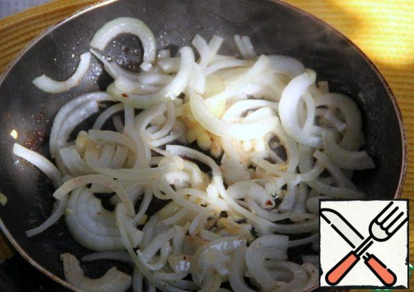 In the same oil with meat juices, fry the onion cut into half rings until it becomes transparent.
Who likes more " hot " taste, at this stage you can add finely chopped chili.