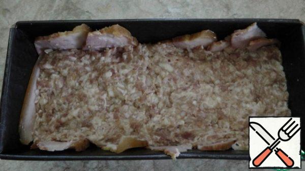 A rectangular shape for baking is lined with slices of bacon, then a layer of half the mass of chopped meat.