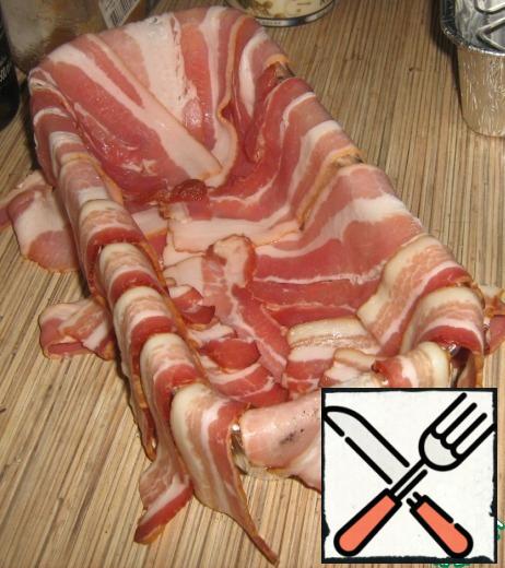 Take two packs (200 grams) of smoked bacon and spread them the walls and the bottom of the form, hanging the "tongues" of bacon outside the form.
