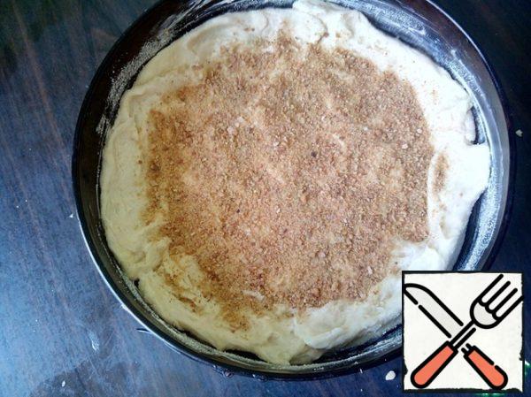 I took a detachable mold with a diameter of 26 cm. Divide the dough into 2 unequal parts. One covered the cookies with the sides. Sprinkle with breadcrumbs.
