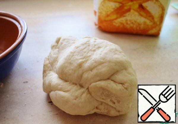 Now in dry mixture of pour in vegetable oil and yeast, knead soft elastic dough, which not will stick to hand. Grease a bowl with vegetable oil and put our dough. Cover the bowl and place in a warm place for about an hour. The dough will grow about 2 times.