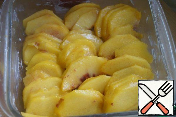 Wash peaches, peel, remove bone and cut into thin slices. A baking dish (size 20*20) grease with butter and spread on the bottom of the peaches in a single layer.