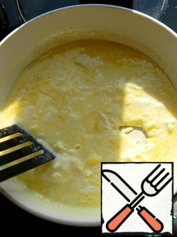 Melt the butter in a frying pan, break the eggs and add the milk immediately.