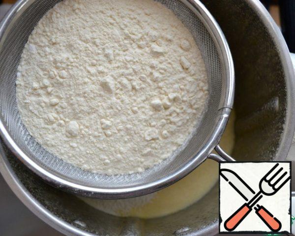 Then sift the flour, potato starch, baking powder and vanillin. Add lemon zest.