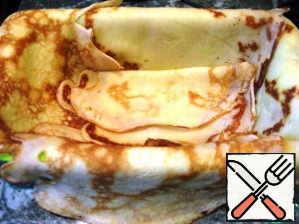 Cover the cake pan with cling film. She laid out the pancakes so that the edges hung down.
