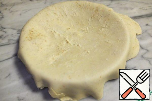 I took a 24 cm form. Put the dough into the mold so that the edges hang down strongly. Carefully distribute the dough into the mold.

