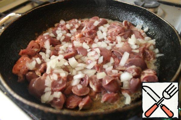 Cut the liver and hearts (pre-soaked to remove blood) into small pieces and fry in olive oil with finely chopped onions.
At the same time, put 2 tomatoes and half a bell pepper in the oven, preheated to 180 ° C. Remove the tomatoes after 10 minutes, and the peppers after 20 minutes. This is necessary in order to be skin.
