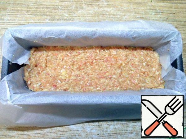 Form for baking for convenience, cover with parchment, grease 1 tsp vegetable oil. Spread half of the minced meat, level with a spoon.