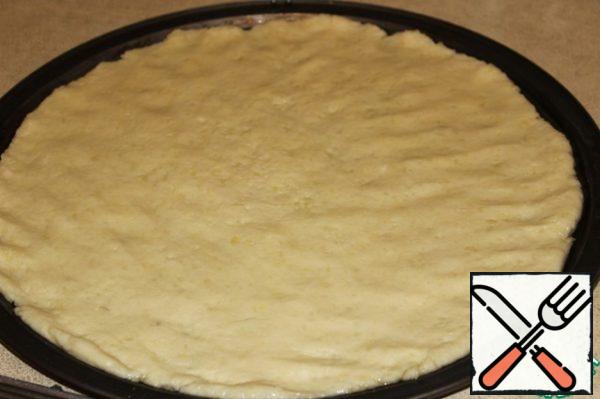 Place the potato dough in a greased with vegetable oil form and smooth with your hands.
