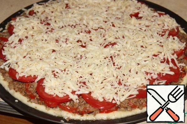 Separately fry the minced meat until half-cooked.
Then combine the vegetables with the minced meat, season with spices.
Put the stuffing and slices of tomatoes, sprinkle with grated cheese.
Bake for 40 minutes at 180 g. Decorate with chopped herbs.