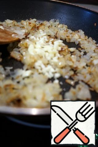 Garlic finely chop. Add it to the onion and fry together for about a minute. Spread the onions from the pan.