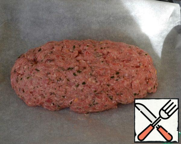 Knead everything thoroughly with your hands. Put the minced meat on a baking sheet covered with baking paper and form a large meatball - bun with your hands!
