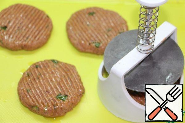 With the help of a special device for cutlets, level the cutlets (either with your hands and fork, or with a potato masher, greased with oil, the minced meat turns out to be quite sticky).
