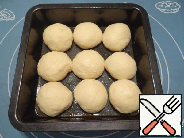 Put the dough and divide into 9 equal parts, molded balls. For baking this bread, I used a square shape measuring 19*19 cm, but you can use a round shape. Form of grease with vegetable oil, evenly spread out the balls of dough.