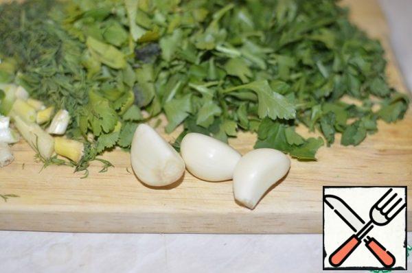 While the dough is being prepared in a bread maker, chop the greens and peel the garlic.