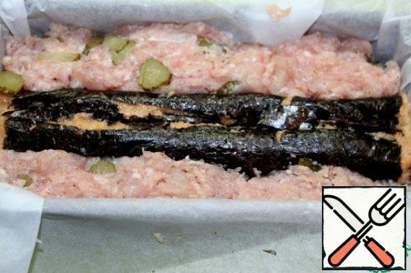 Put the filling on a sheet of nori, roll up.
Put the roll on top of the minced meat, slightly drowning it, cut the spoon "mash" the sides of the roll, then to cut the filling was unevenly. 