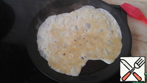 Fry pancakes: grease the pan with oil, pour the egg on one side.