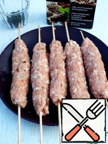 Wooden skewers should be soaked in water in advance. You can fry on the metal, but the stuffing should be fairly thick, otherwise from the sharp skewers it all peel off on the grill.
Wrap skewer stuffing, hands to give the same shape is not thick.