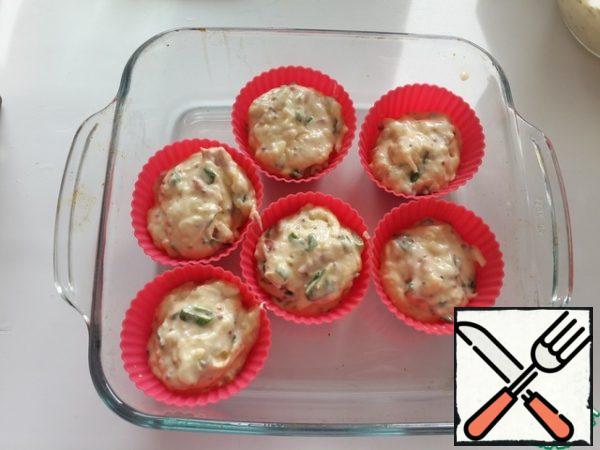 Spread the dough on the cake molds.

