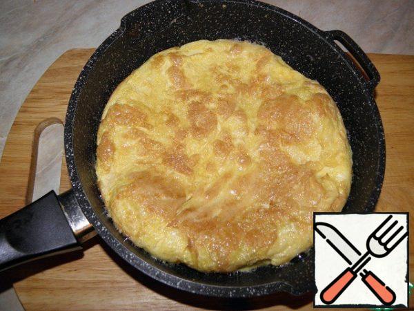 Pour the eggs on a heated, greased with vegetable oil pan, fry the pancake on both sides.