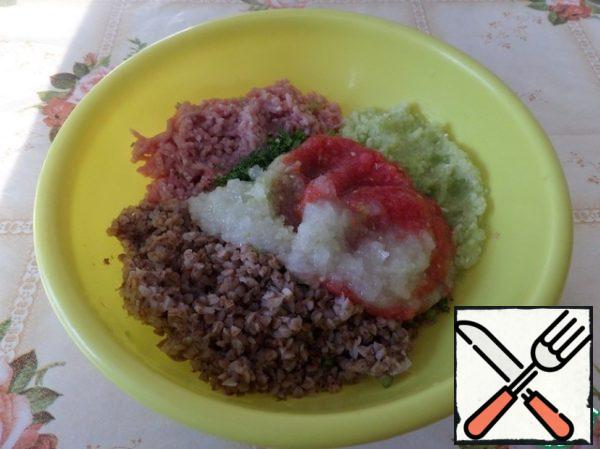 In a deep bowl, put boiled buckwheat, minced meat, chopped zucchini, carrots.
Add 1/2 part of the tomato-onion mixture, herbs and salt (spices to taste).
