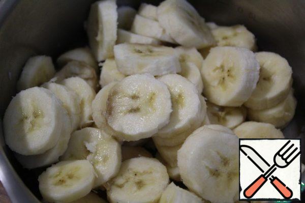Bananas cut into circles, folded into a saucepan, add sugar and pour in the two juices.