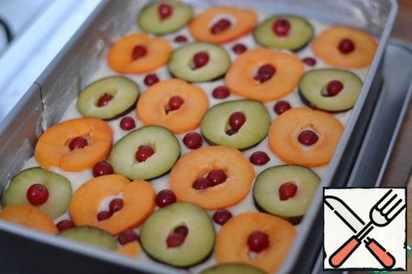 Alternately spread the fruit on the dough.
We put red currant berries in the fruit hole.
