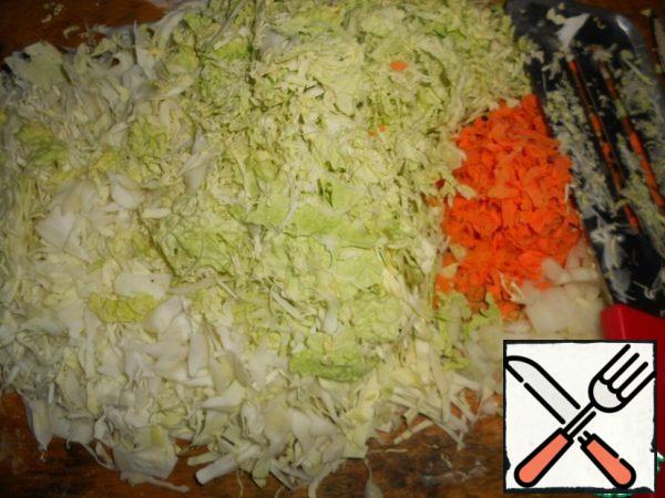 While the dough is being prepared, prepare the filling.
Chop the cabbage, grate the carrots on a coarse grater, peel the onion and finely chop.

