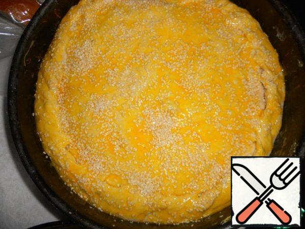 Brush the pie with beaten egg yolk and sprinkle with sesame seeds.
