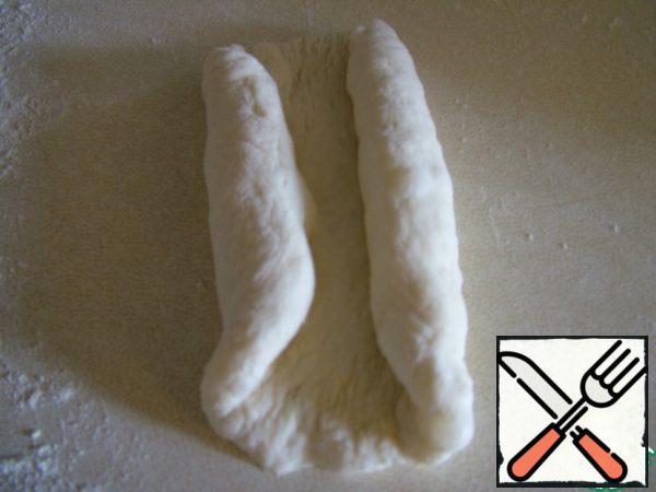 Form buns. To do this, each piece of dough is rolled into a cake and rolled from the edges to the center.