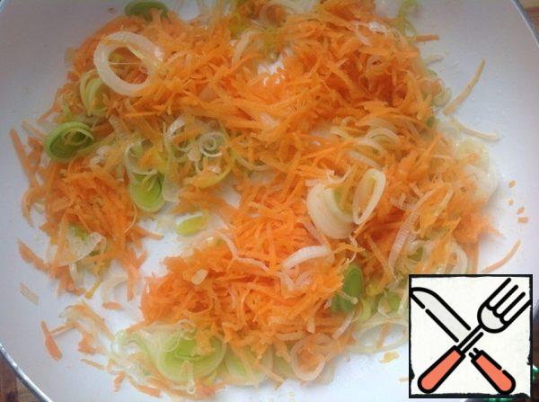 In a frying pan with heated vegetable oil, fry the onion for 5 minutes, add the carrots and fry.
