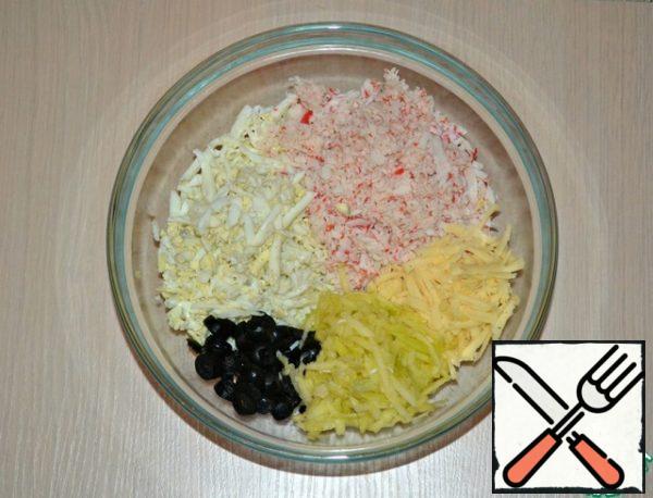 Connect in deep capacity 50 g cut into half-rings olives, crab sticks, eggs, cheese, grated on a large grater juicy green Apple.
