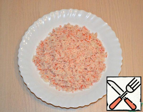 Frozen (so it will be easier to rub) crab sticks grate on a coarse grater.
