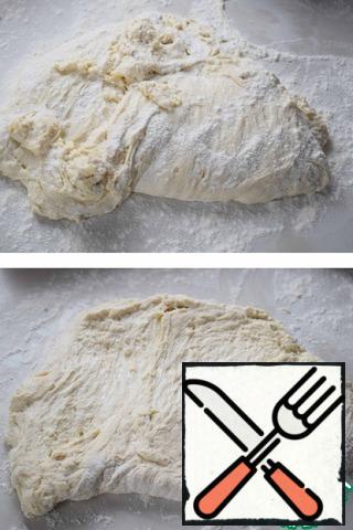Spread the dough with a scraper on a floured table and, with a scraper,stretch the dough into a layer (about 1-1.5 cm thick).