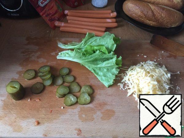 While the sauce is stewing, grate the cheese on a medium grater, cut the cucumbers into thin circles, tear the salad into leaves (after washing, dry them thoroughly).