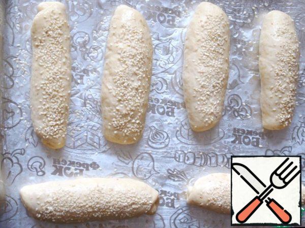 Lay baking sheet with baking paper or foil, grease with vegetable oil. Put on a baking bun seam down, grease, using a silicone brush, milk or water and sprinkle with sesame seeds. Leave for 15 minutes in a warm place, and then bake in the oven, preheated to 180 degrees, 20-25 minutes.