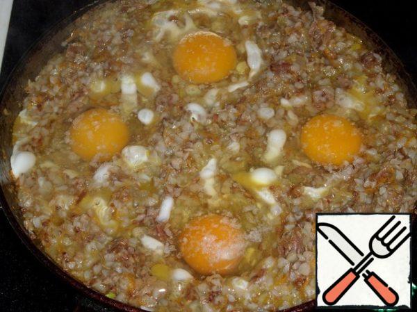 Use a spoon to make a small depression in the buckwheat porridge. Break a chicken egg into these recesses. Salt. Cover the pan with a lid.
