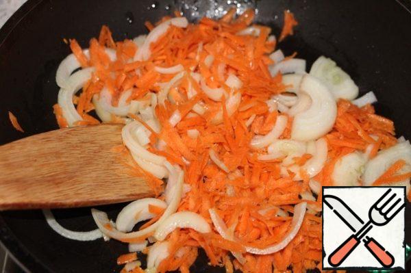 In a large frying pan with high sides, a saucepan with a thick bottom or a cauldron, heat the vegetable oil, then chop the onion with garlic and grated carrots for 2 minutes.
