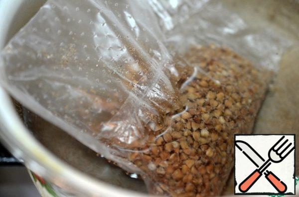 Boil the buckwheat. Boil the salted water, drop the bag of buckwheat. Cook on low heat for 20 minutes. Then let the water drain. Open the bags and add the butter.