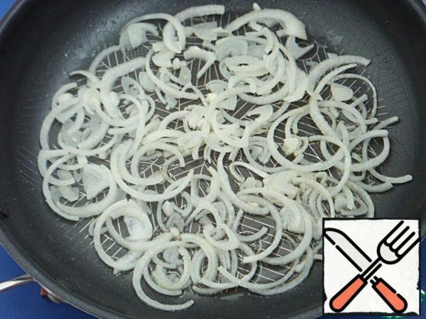 Get bags of buckwheat. While the water drips, quickly fry the vegetables.
Heat the pan, pour 2 tablespoons sesame oil. Fry half-rings of onions, without reducing the fire, just a minute. He's just starting become transparent.