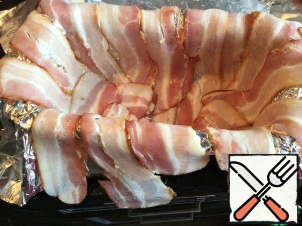 Cover the form with foil, put the bacon, so that the edges hang down.