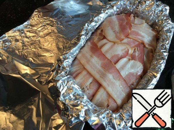 Close the hanging edges of the bacon. Cover with foil and bake in a preheated 170 degree oven for 1 hour.